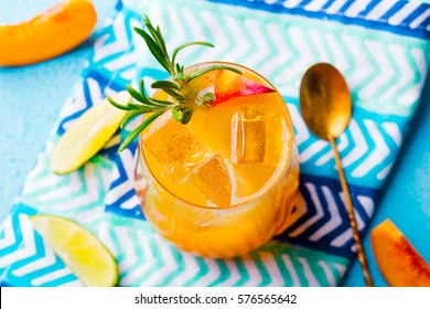 Peach Cocktail, Fizz, Ice Tea With Fresh Rosemary And Lime. Blue Background.