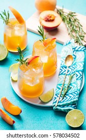 Peach Cocktail, Fizz, Ice Tea With Fresh Rosemary And Lime. Blue Background.