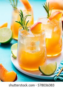 Peach Cocktail, Fizz, Ice Tea With Fresh Rosemary And Lime. Blue Background.