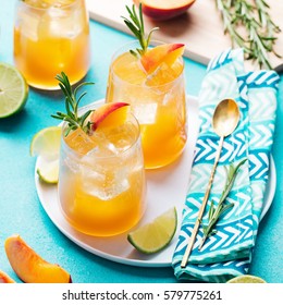 Peach Cocktail, Fizz, Ice Tea With Fresh Rosemary And Lime. Blue Background.