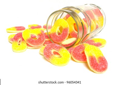 Peach Flavored Candy Rings And Glass Jar On White Background