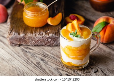 Peach Fruit Dessert In Glass Cup On Wooden Table. Homemade Dessert With Fruits. Fruit Salad With Yogurt Or Sour Cream.