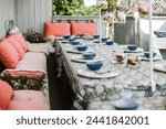 Peach fuzz and blue decorations on a outdoor table set for a summer party.