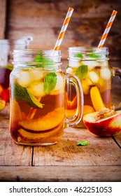 Peach Ice Tea In Mason Jar With Mint On Wooden Table