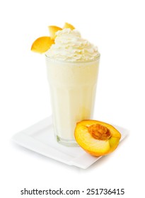 Peach milkshake with whipped-cream on the top and fresh pieces of peach. 