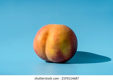 Peach On A Blue Background As A Female Body Shape Like Buttocks, Thighs, Pelvis, Pubis. Metaphor Of Sex, Sexuality, Vagina 