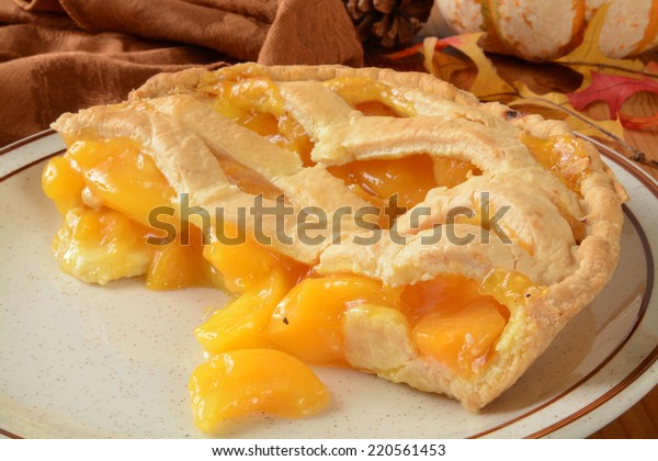 A peach pie with lattice crust on a holiday\
decorated table