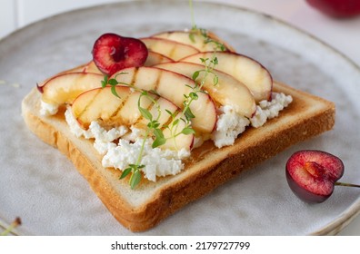 Peach And Ricotta Toast Topped With Honey On A Plate Close-up