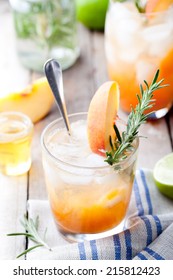 Peach And Rosemary Fizz Cocktail On A Wooden Background.