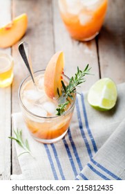 Peach And Rosemary Fizz Cocktail On A Wooden Background.