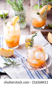 Peach And Rosemary Fizz Cocktail On A Wooden Background.