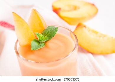 Peach smoothie dessert (mousse) with mint in portion glass