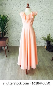 Peach vintage fashion long maxi dress chiffon ruffle neck bridesmaid wedding luxury dress tailor made by a dressmaker, a dress on mannequin sewing dress form in the plain room