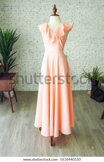 Peach\
vintage fashion long maxi dress chiffon ruffle neck bridesmaid\
wedding luxury dress tailor made by a dressmaker, a dress on\
mannequin sewing dress form in the plain\
room