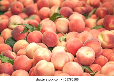 Peaches close up. Early morning in farmers market. Colorful fruit background 