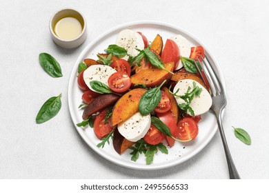 Peaches, tomatoes, mozzarella salad in plate on  white background. Caprese italian traditional salad top view - Powered by Shutterstock