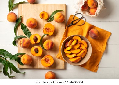 Peaches whole fruits with leaves, peaches in halves, peach slices on a white kitchen table. The process of making peach jam, cooking peach dessert on a cutting board. Pastry chef work place. Flat lay - Powered by Shutterstock