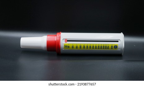 A Peak Flow Meter With A Disposable Mouthpiece. Peak Flow Test Used In The Treatment Of Asthma. Image Isolated On A Black Background.