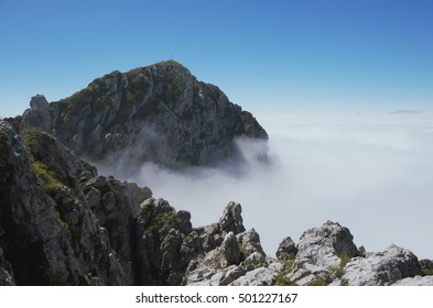Peak of mountain above the clouds. 
View above clouds. Mount Alben, Lombardy, Italy
