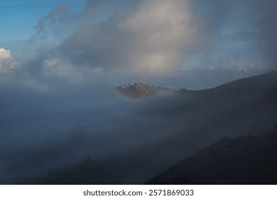 Peak of the mountain between the clouds in the evening