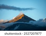 peaks. mountain peaks against the blue sky shrouded in clouds