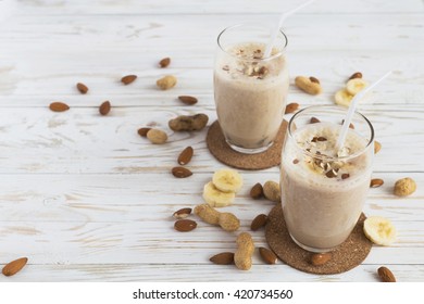 Peanut And Almond Butter Banana Oat Smoothie With Paper Straws On A Wooden Rustic Table