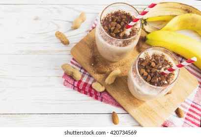 Peanut And Almond Butter Banana Oat Smoothie With Paper Straws On A Wooden Rustic Table