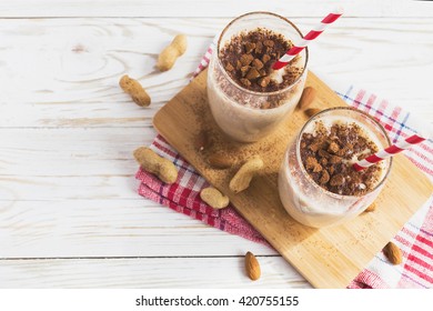 Peanut And Almond Butter Banana Oat Smoothie With Paper Straws On A Wooden Rustic Table