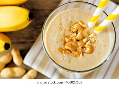 Peanut Butter Banana Oat Smoothie With Paper Straws Close Up, Downward View With Cloth