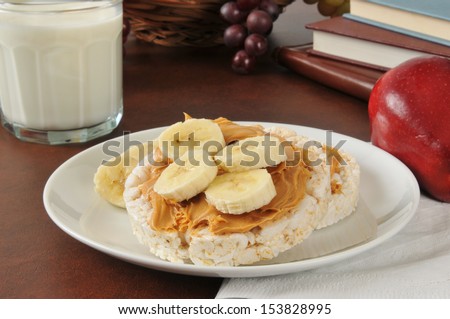 Peanut butter and banana on a rice cake with an apple and milk after school