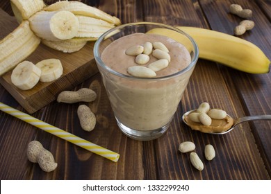 Peanut Butter Banana Shake In The Glass On The Brown Wooden  Background