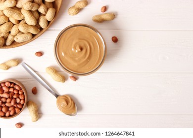 
peanut butter and peanut beans on wooden background