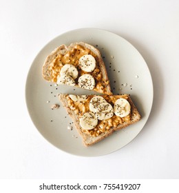 Peanut Butter Chia Seed Banana Toast For Breakfast On A White Background, Healthy Snack, Top View