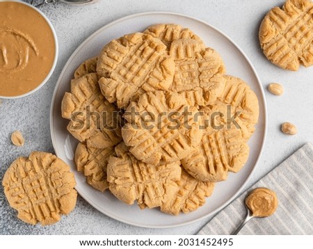 Peanut butter cookies on ceramic plate. Closeup, top view. Traditional american dessert, crunchy snack or breakfast food. Biscuits made of homemade nut butter, sugar, eggs and flour. 