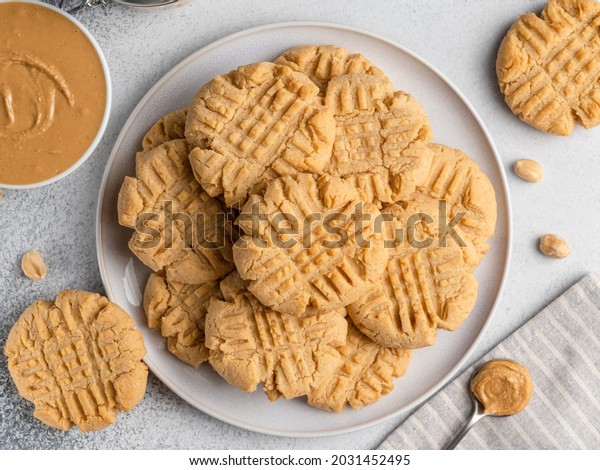 Peanut\
butter cookies on ceramic plate. Closeup, top view. Traditional\
american dessert, crunchy snack or breakfast food. Biscuits made of\
homemade nut butter, sugar, eggs and flour.\
