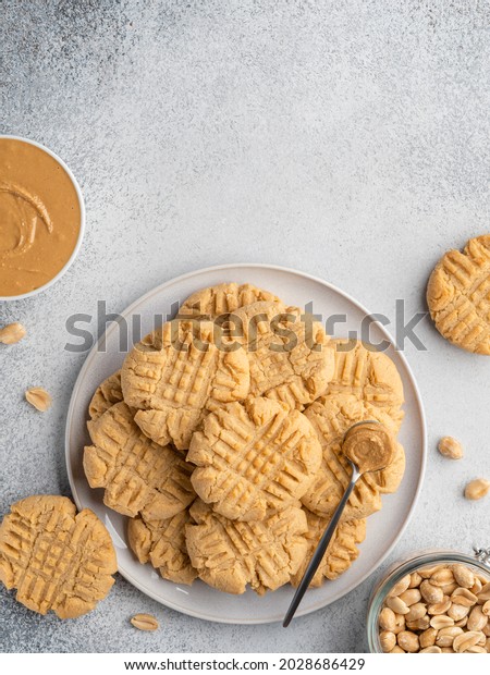 Peanut butter cookies pile on ceramic plate. Top view,\
copy space. Traditional american dessert, chewy snack, dessert or\
breakfast food. Biscuits made of homemade nut butter, sugar, eggs\
and flour. 