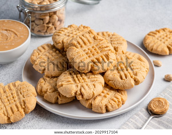 Peanut\
butter cookies stacked on ceramic plate. Close up view. Traditional\
american dessert, snack, dessert or breakfast food. Biscuits made\
of homemade nut butter, sugar, eggs and\
flour.