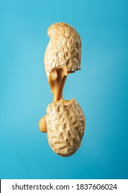 Peanut Butter Flows Out Of The Broken Peanuts On A Blue Background. 