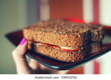 Peanut Butter Jelly Sandwich On Plate PBJ In Woman's Hand