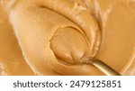 Peanut butter Mixing with golden spoon, close up. Creamy smooth peanut butter