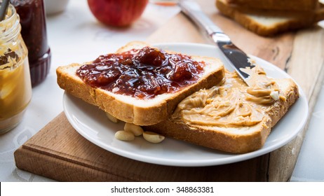 Peanut butter and raspberry jelly sandwich on wooden background. Perfect sweet breakfast. Close up. - Powered by Shutterstock