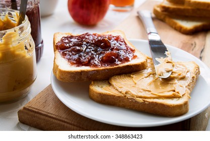 Peanut butter and raspberry jelly sandwich on wooden background. Perfect sweet breakfast. Close up.
