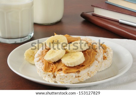 Peanut butter sandwich on a rice cake with milk as an after school snack