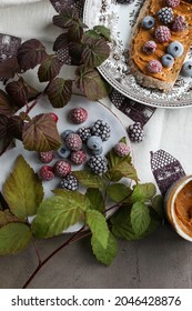 Peanut Butter Sandwich On A Vintage Plate On The Table With Flowers And Leaves. Frozen Various Berries For Lunch. Light Breakfast.