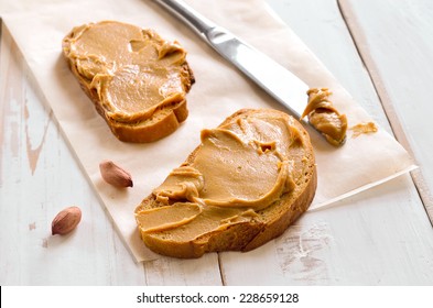 Peanut butter sandwiches or toasts  on light wooden background