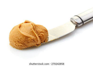 Peanut Butter Spread On A Knife Isolated On White Background