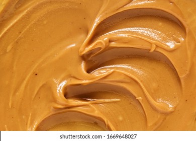 Peanut Butter Texture Background. Brown Nut Paste Smear Close Up. Delicious Natural Food Creamy Smooth Spread Macro Top View