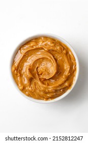 Peanut Butter In A White Saucer On White Background. Curl Of Peanut Butter. Top View.