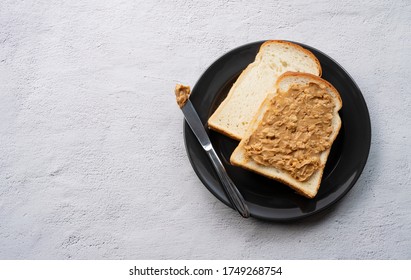 Peanut buttered bread set against a backdrop of sparse stones