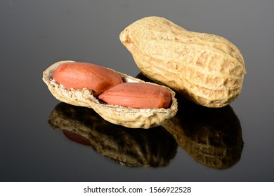 Peanut on glossy black surface with reflection. Whole peanut and open shell with two kernels macro close up, high resolution full depth of field. - Powered by Shutterstock